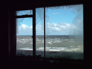 Image of the view of the horizon through a broken window.