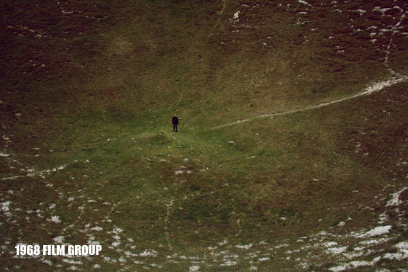 Image of a man standing in a vast field.